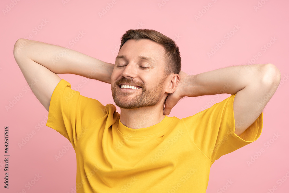 Positive dreamer guy with relaxed hands behind head smiles isolated on pink studio background. Concept of emotion and good mood. Pleased satisfied man resting with closed eyes copy space for promotion Positive dreamer guy with relaxed hands behind head smiles isolated on pink studio background. Concept of emotion and good mood. Pleased satisfied man resting with closed eyes copy space for promotion
