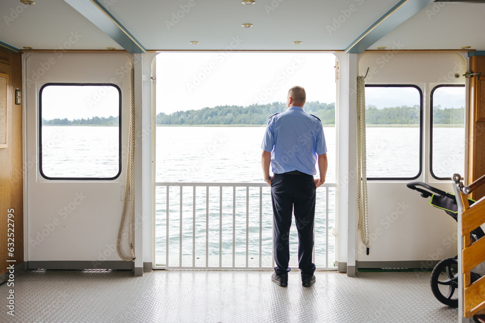 Man looking out the window of a ferry on the Chiemsee Lake in southern Germany Man looking out the window of a ferry on the Chiemsee Lake in southern Germany