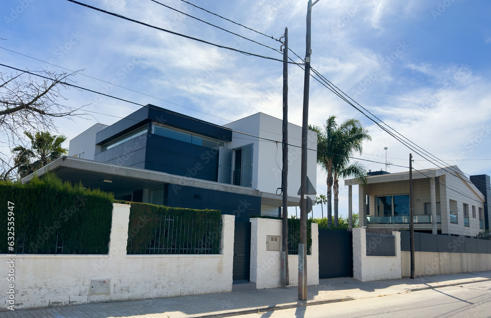 Gate and brick wall of fence on street sidewalk. Villa with Garden. Fence at a suburb house. Design house and luxury facilities. Garden Home building Exterior. Luxury Villa with palm trees in garden. Gate and brick wall of fence on street sidewalk. Villa with Garden. Fence at a suburb house. Design house and luxury facilities. Garden Home building Exterior. Luxury Villa with palm trees in garden.