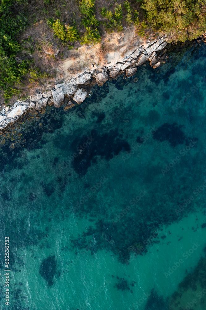 Aerial view to a beautiful rocky beach at sunset	
