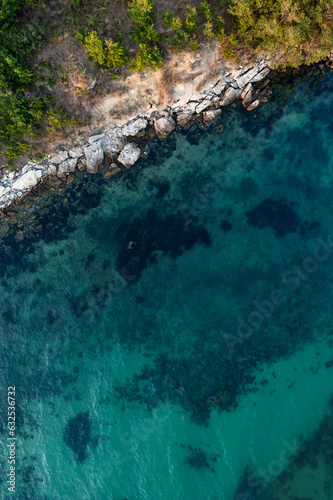 Aerial view to a beautiful rocky beach at sunset 