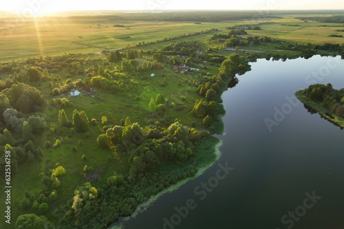 Lake in rural on sunset  drone view. Rural landscape with lakes. Drink water safe. Global drought crisis. Pond in countryside with fields. Green farm field and farmland in Country. Village at lake.
