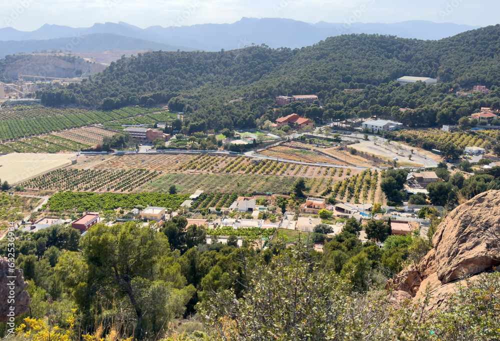 Obraz premium Villa in mountains. Rural landscape, aerial view. Farmhouse with garden field. Houses at mountain in countryside. House in farm field. Mountains landscape with farmland. Village Home in mountains.