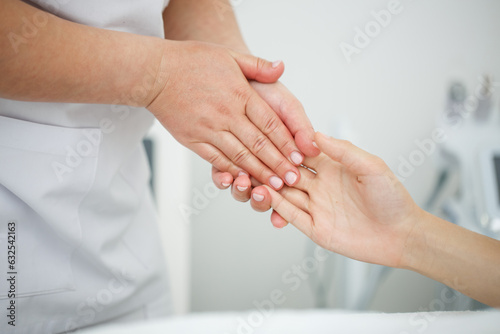 Close up massage of a woman's hands in the interior of a beauty salon on a white background