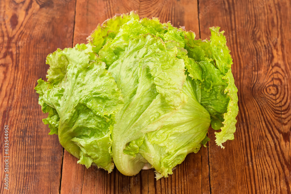 Head of fresh iceberg lettuce on a rustic table Head of fresh iceberg lettuce on a rustic table