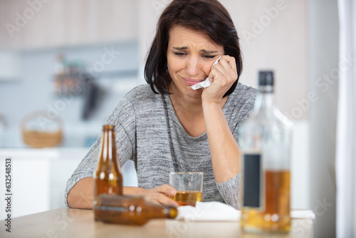 young brunette sitting by bar looking sad