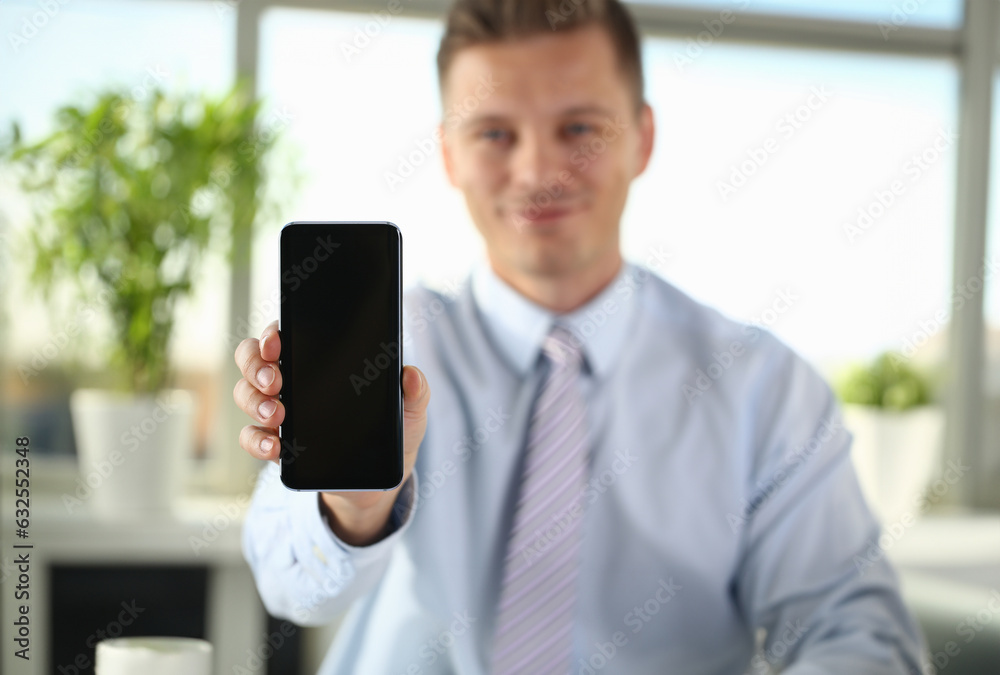 A businessman holds a new smartphone in his hand mobile application market shows display you can insert your image for advertising or financial statistics.