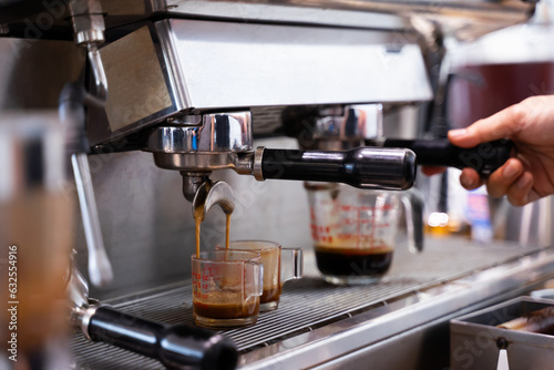 The barista makes latte art coffee with an espresso machine