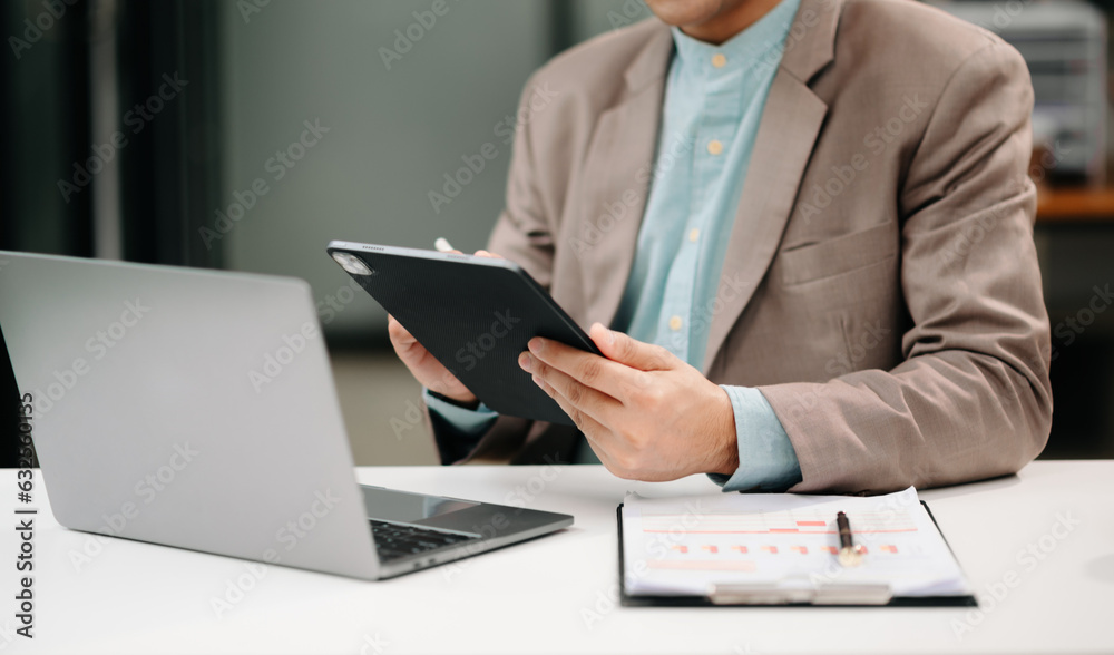 Businessman s hands typing on smartphone, tablet and laptop keyboard computer, typing, online in office. Businessman s hands typing on smartphone, tablet and laptop keyboard computer, typing, online in office.