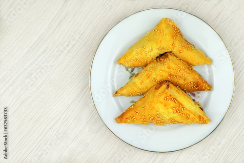 Eastern cuisine. Samosas in a plate on a wood background. Home cooking. Fast food.