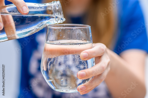 Woda nalewana do szklanki ze szklanej butelki © Paweł Kacperek