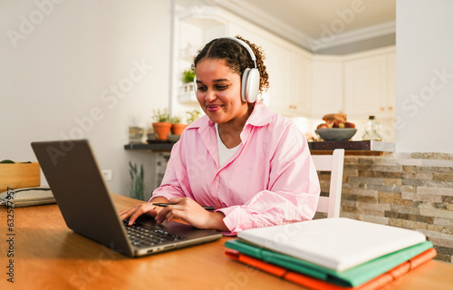Girl using laptop computer from home while studying at college homework project - Back to school and student lifestyle concept -Focus on face