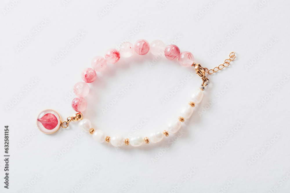 pink and white bracelet made of natural stones on white background pink and white bracelet made of natural stones on white background