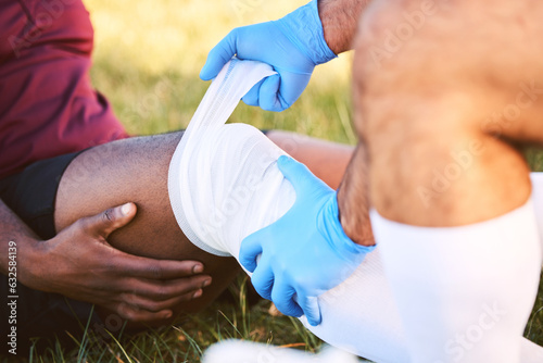 Bandage, knee pain and injury, medic help athlete and sports accident on field with health and wellness. People outdoor, paramedic dressing wound and medical care with inflammation and fracture