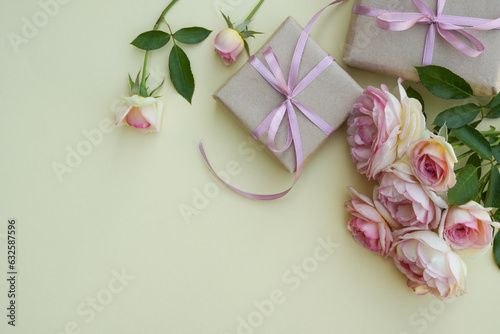 Fototapeta Naklejka Na Ścianę i Meble -  Valentine's Day design concept background with light pink roses and wrapped kraft gift box on beige background. Flower card. Holiday, congratulations, happy mothers day. International Women's day.