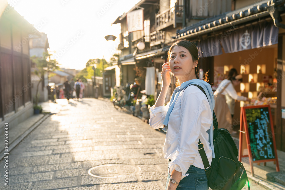 backlit-curious-asian-japanese-woman-visitor-turning-around-to-look-at