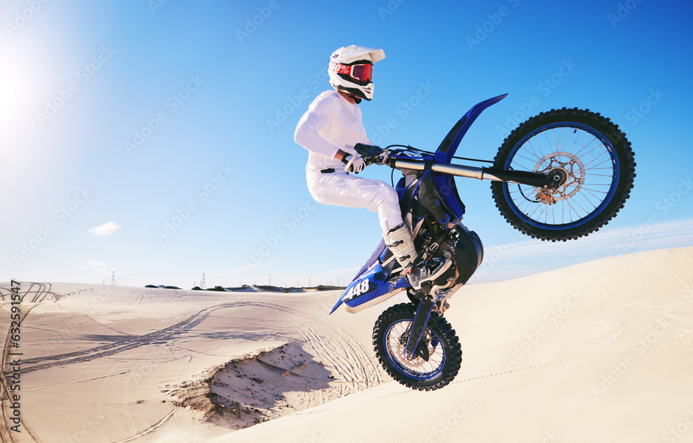 Naklejka premium Jump, sports and man on motorcycle on sand for adrenaline, adventure and freedom in desert. Action, extreme motorbike and male person on bike on dunes for training, exercise and race or challenge