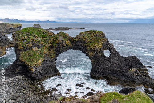Amazing stone arch Gatklettur basalt rock on Atlantic coast of Arnarstapi in Iceland photo