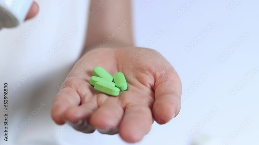 Pour the tablets from the white bottle into your hand. Vitamins and dietary supplements close-up. Daily dose of vitamins Pour the tablets from the white bottle into your hand. Vitamins and dietary supplements close-up. Daily dose of vitamins