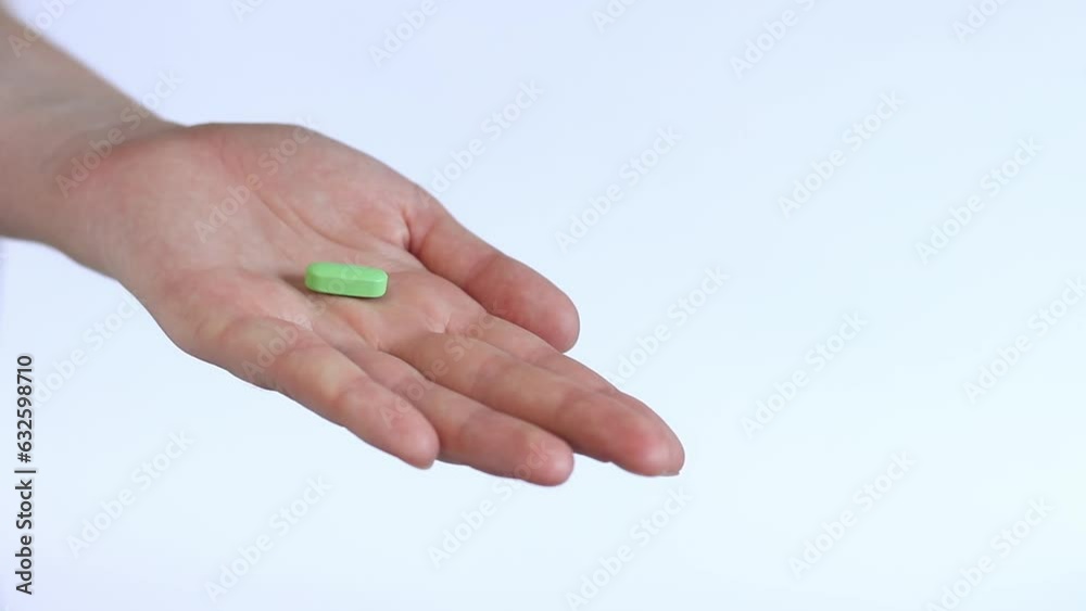 Pour the tablets from the white bottle into your hand. Vitamins and dietary supplements close-up. Daily dose of vitamins Pour the tablets from the white bottle into your hand. Vitamins and dietary supplements close-up. Daily dose of vitamins