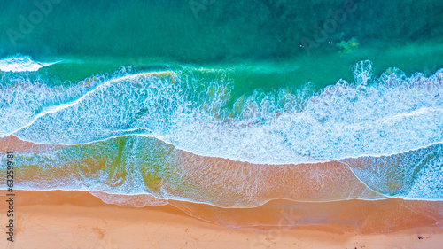 Beautiful ocean beach with yellow sand, aerial view. Drone view of blue waves and sandy beach. Top view - Beautiful Ericeira sandy beach is famous tourist destination for surfing. Portugal..