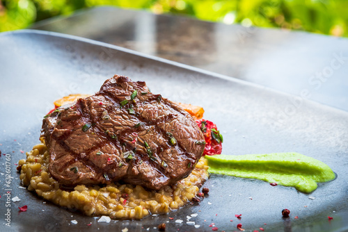 Grilled Beef Steak And Risotto. Beef steak with vegetables on a plate.