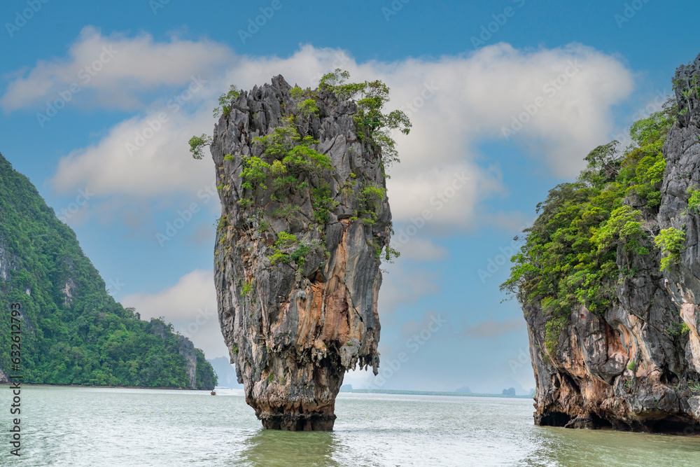 Obraz premium Famous James Bond island near Phuket in Thailand. Travel photo of James Bond island with thai traditional wooden longtail boat and beautiful sand beach in Phang Nga bay, Thailand.