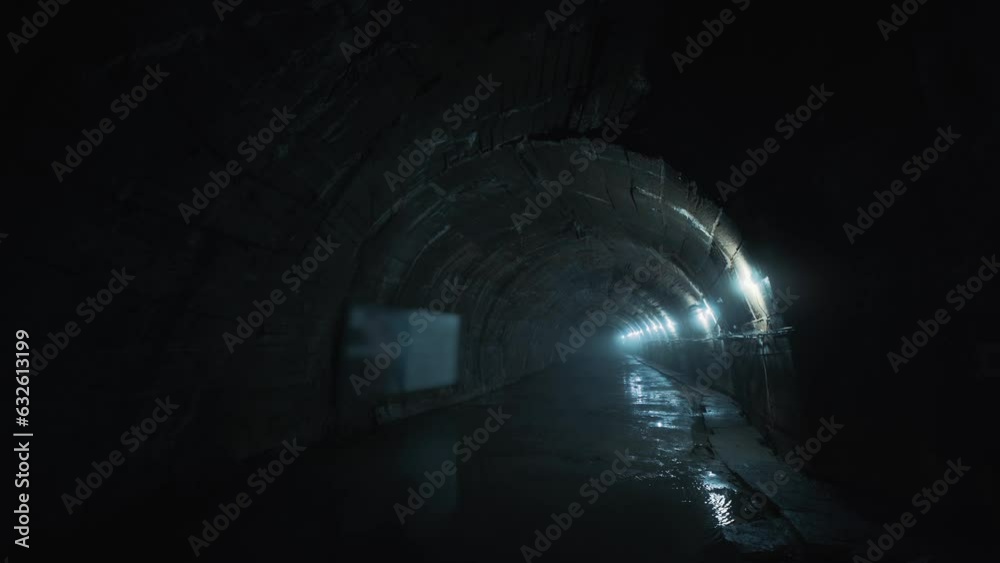 Long concrete underground industrial tunnel or corridor.