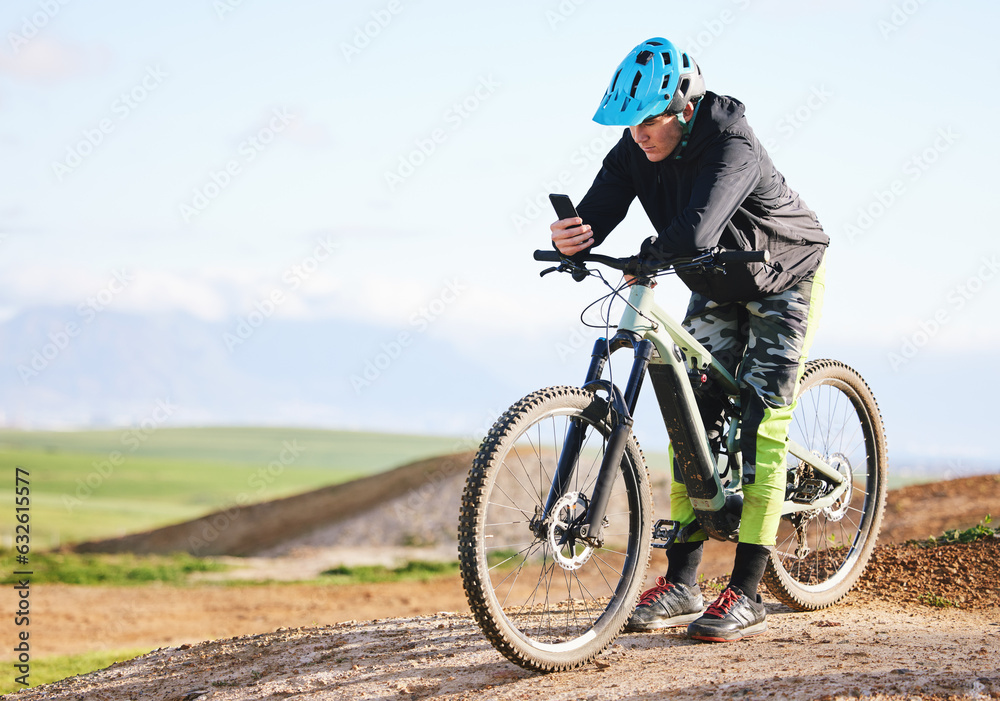 Fitness, nature and man cycling with phone for direction, social media or reading a notification. Sports, communication and cyclist or person on a bike with a mobile app for progress in the mountains