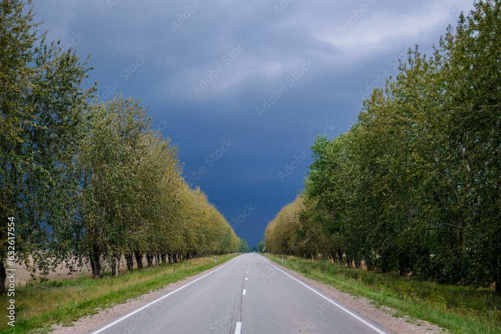 A lonely road in the summer before a threatening storm. Storm in summer. thunder clouds. A lonely road in the summer before a threatening storm. Storm in summer. thunder clouds.