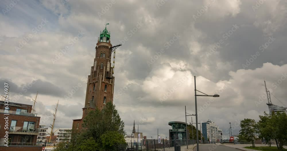 Timelapse in front of an tall and old looking lighthouse building, Big moving clouds and a beautiful skyline, Cityscape of Bremerhaven in Germany, travel destination, Summer vibes