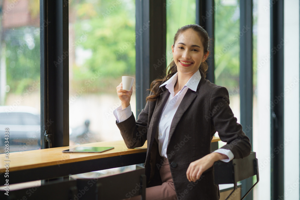 Beautiful young Asian woman having a relaxing time enjoying coffee in a cafe. Beautiful young Asian woman having a relaxing time enjoying coffee in a cafe.