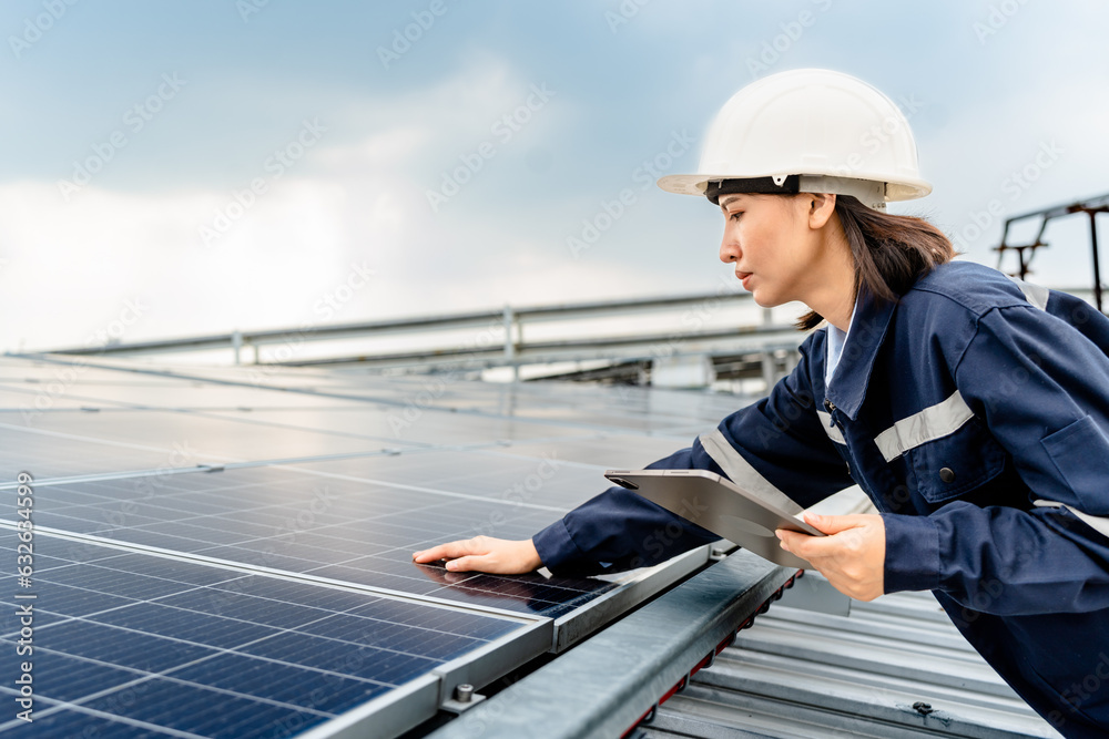 Woman engineer electrician using a hand to check solar panels on the roof, clean energy power nature, photovoltaic systems, the energy produced by the sun, sustainable business concept. Woman engineer electrician using a hand to check solar panels on the roof, clean energy power nature, photovoltaic systems, the energy produced by the sun, sustainable business concept.