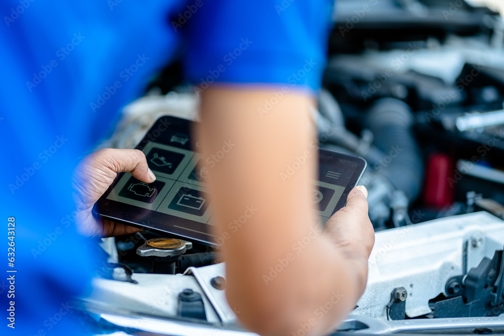 Automotive mechanic repairmen use tablets and check the system working engine of the engine room, check the mileage of the car, oil change, auto maintenance service concept.
