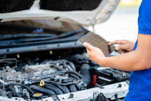 Automotive mechanic repairmen use tablets and check the system working engine of the engine room, check the mileage of the car, oil change, auto maintenance service concept.