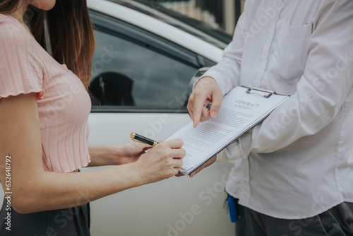 An insurance agent inspects the damaged vehicle and submits a post-accident claim form. Traffic accident and insurance concept