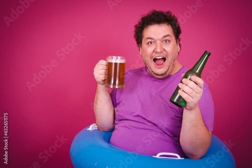 Funny fat man is engaged in vacation at sea drinking beer.