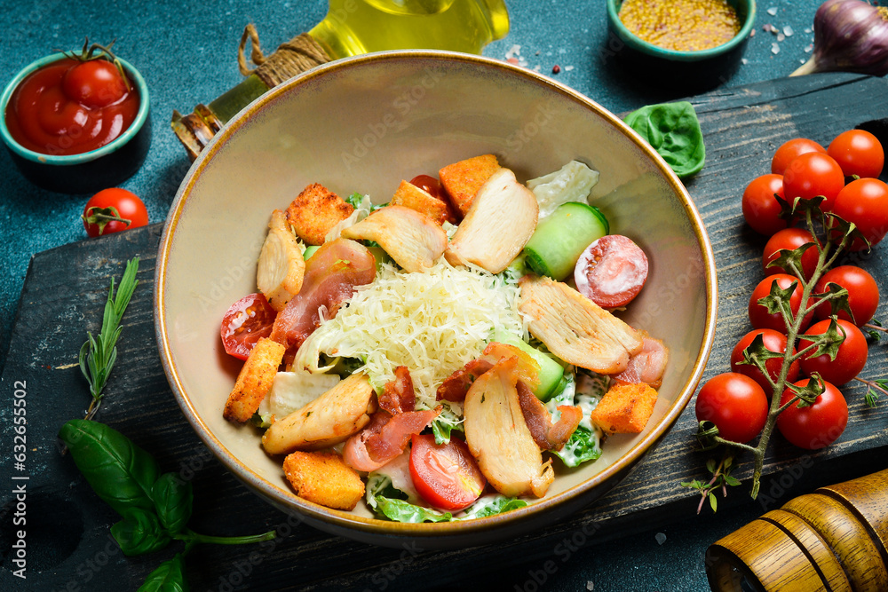 Caesar salad with chicken and vegetables. On a plate. Restaurant serving. Close up. On a dark stone background. Caesar salad with chicken and vegetables. On a plate. Restaurant serving. Close up. On a dark stone background.