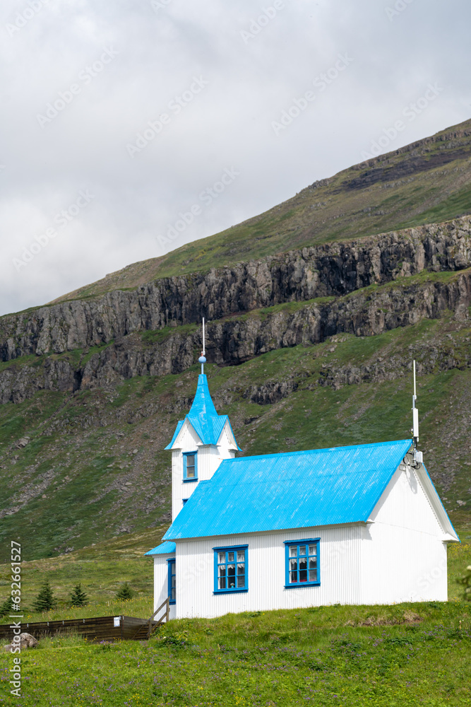 Blue Kirkjubaer church located on the hillside surrounding the fjord, located in Stodvarfjordur, East Iceland. Blue Kirkjubaer church located on the hillside surrounding the fjord, located in Stodvarfjordur, East Iceland.