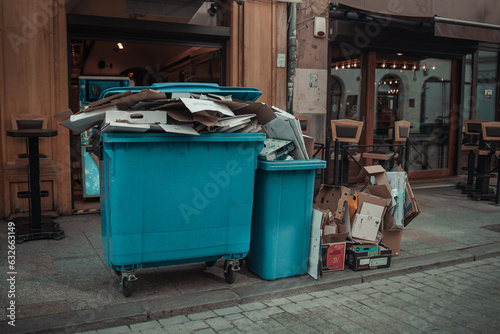 Rows of garbage cans of different colors in an alley in the city center, near a city cafe or restaurant. High quality photo © Shi 