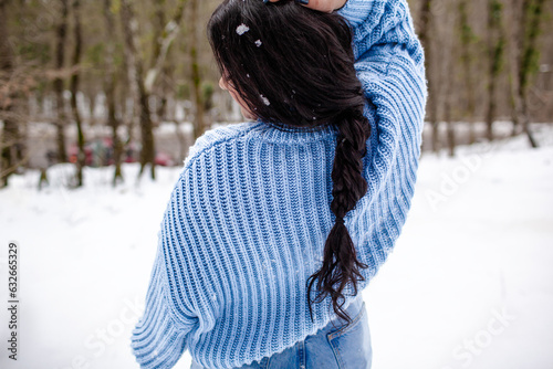 back view woman wearing the white sweater, jeans and hat, the girl in warm cothes. Plus size woman waking, have fun in snow day photo