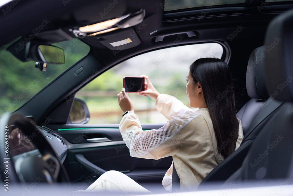 Woman use of mobile phone to take photo inside car