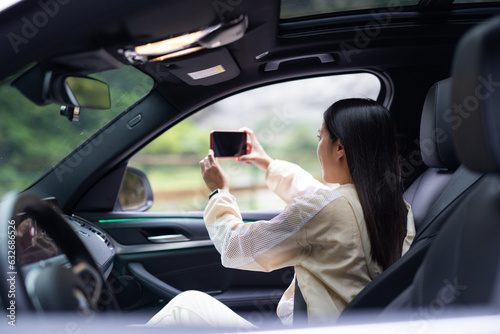 Woman use of mobile phone to take photo inside car © leungchopan