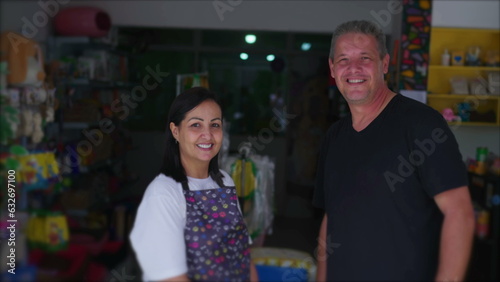 Pet Shop Owner and Customer posing for camera in front of Local Small Business. Female Entrepreneur wearing apron with man