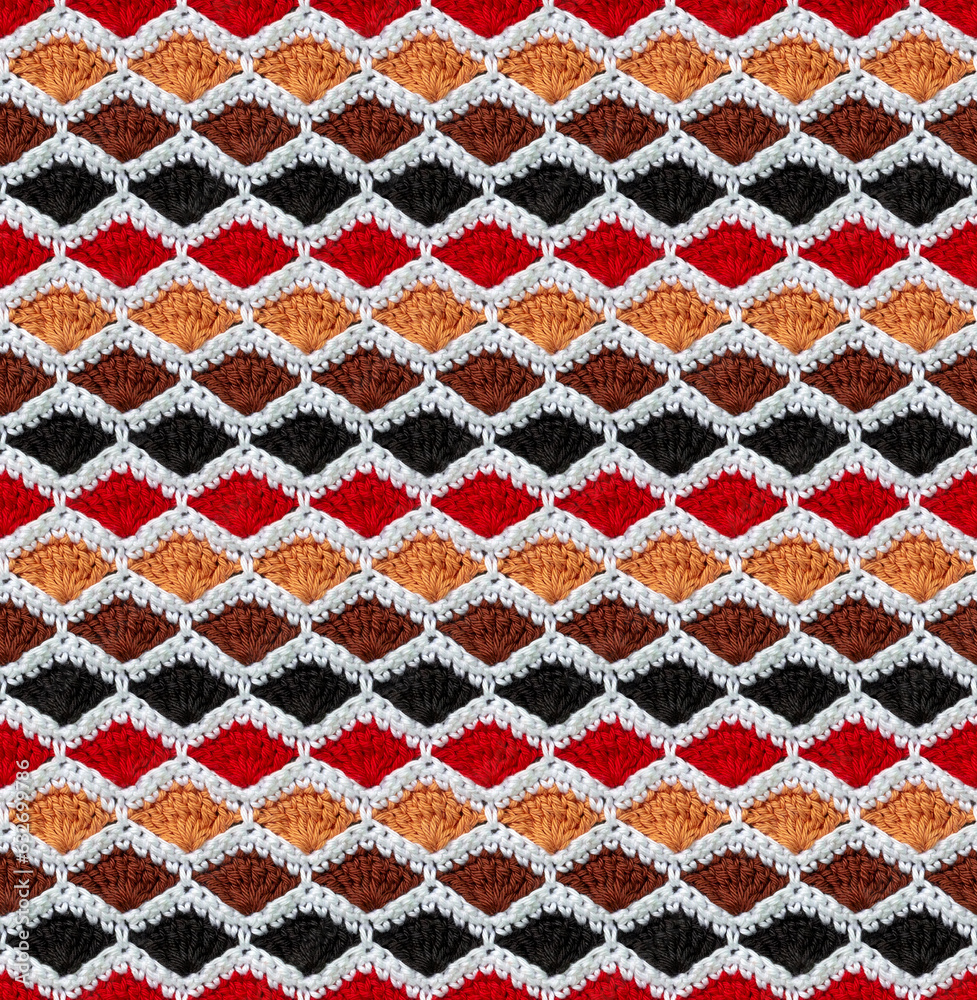 Seamless knitted texture. The pattern in the form of honeycombs is crocheted from colored cotton yarn. Shell design.