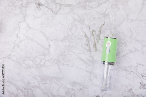 Electronic oral irrigator on marble background. Dental tool for oral hygiene. Electric Interdental Cleaner. Dental water shower. Oral care concept. Place for text. copy space. © Avocado_studio