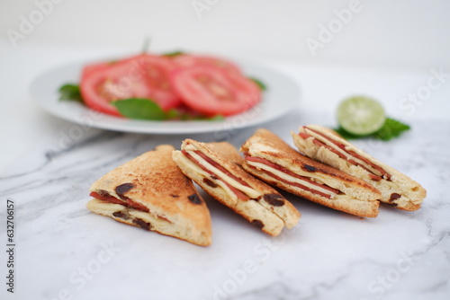 Sandwiches with cheese and cherry tomatoes on a white marble background