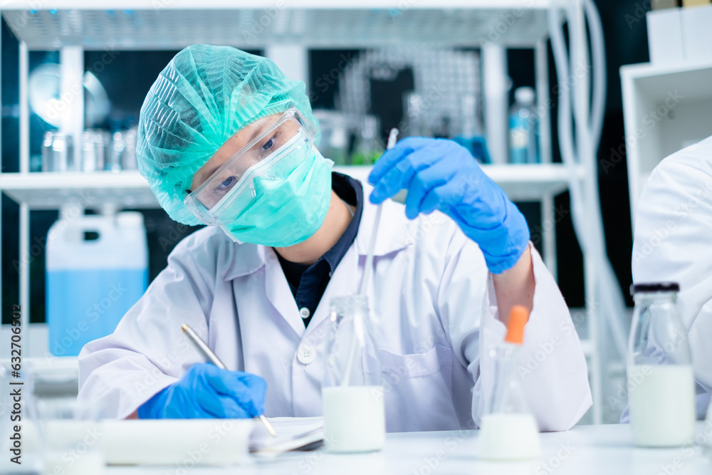Nutritionists or scientists are checking the quality and temperature of dairy milk. Concept of nutrition, lactose, protein, bacteria, fat and glucose laboratory. Dairy milk test and research. Nutritionists or scientists are checking the quality and temperature of dairy milk. Concept of nutrition, lactose, protein, bacteria, fat and glucose laboratory. Dairy milk test and research.