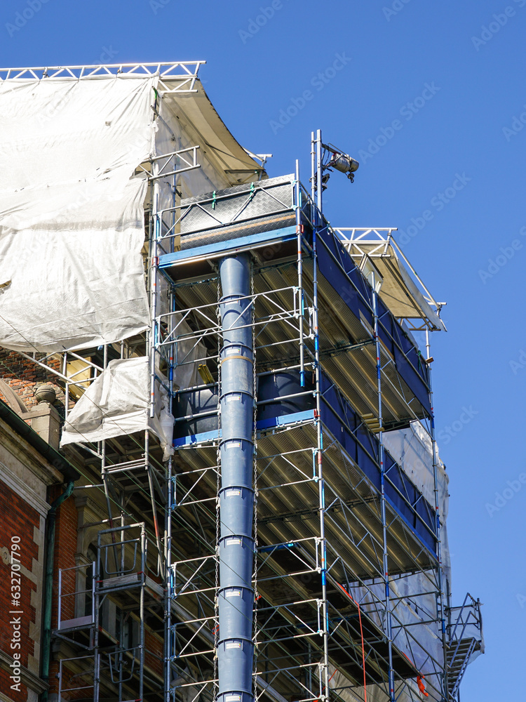 Restoration of the facade of a historic house using scaffolding and construction debris plastic pipe