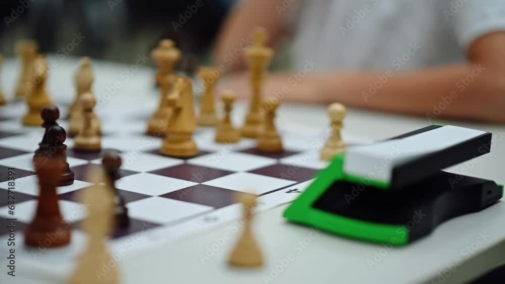 Close-up of a Young Chessman Moving a Chess Piece and Pressing the Chess Clock. Chess Tournament, Competition, Play, Chessboard Close-up of a Young Chessman Moving a Chess Piece and Pressing the Chess Clock. Chess Tournament, Competition, Play, Chessboard